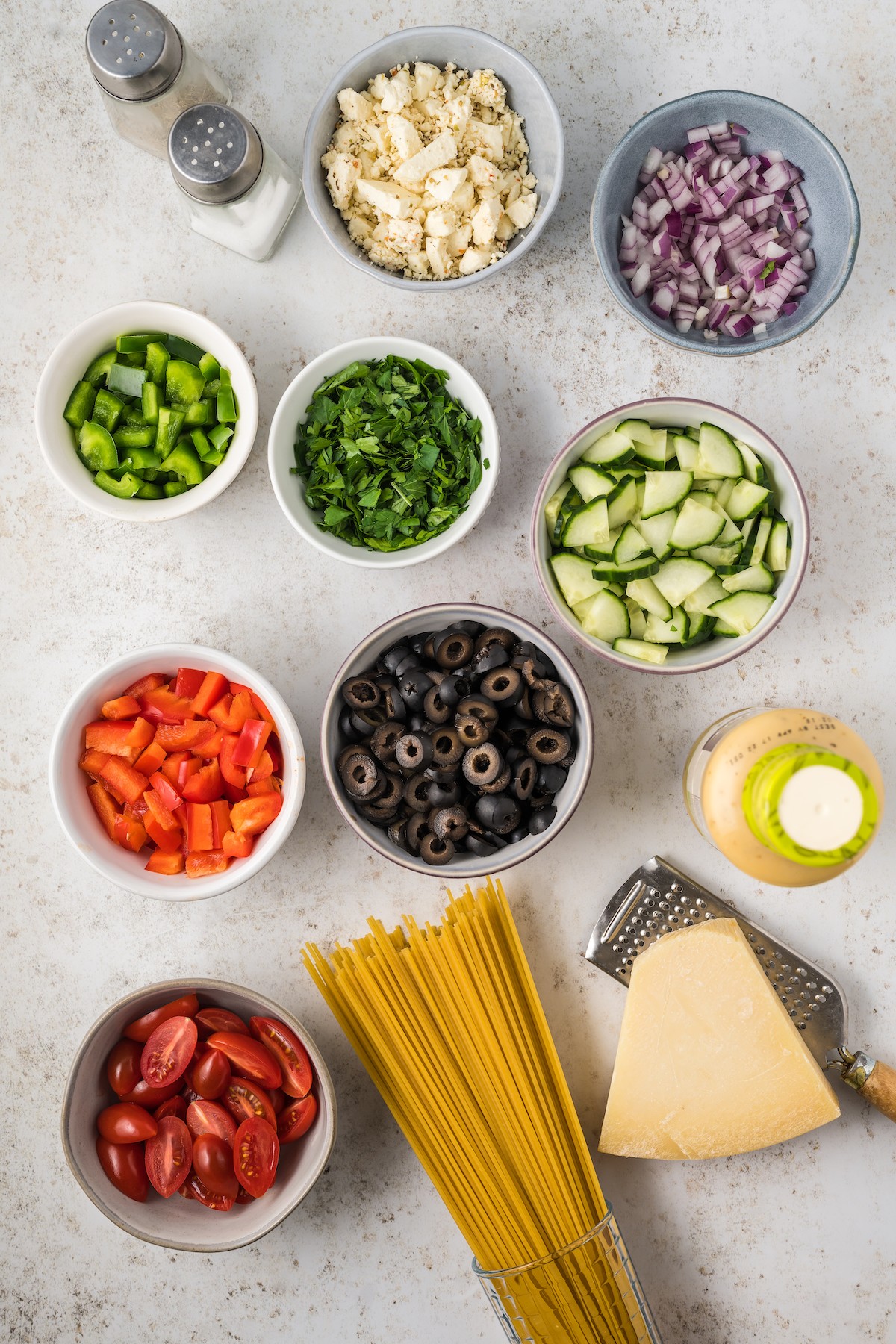 Ingredients for spaghetti salad arranged on a work surface.