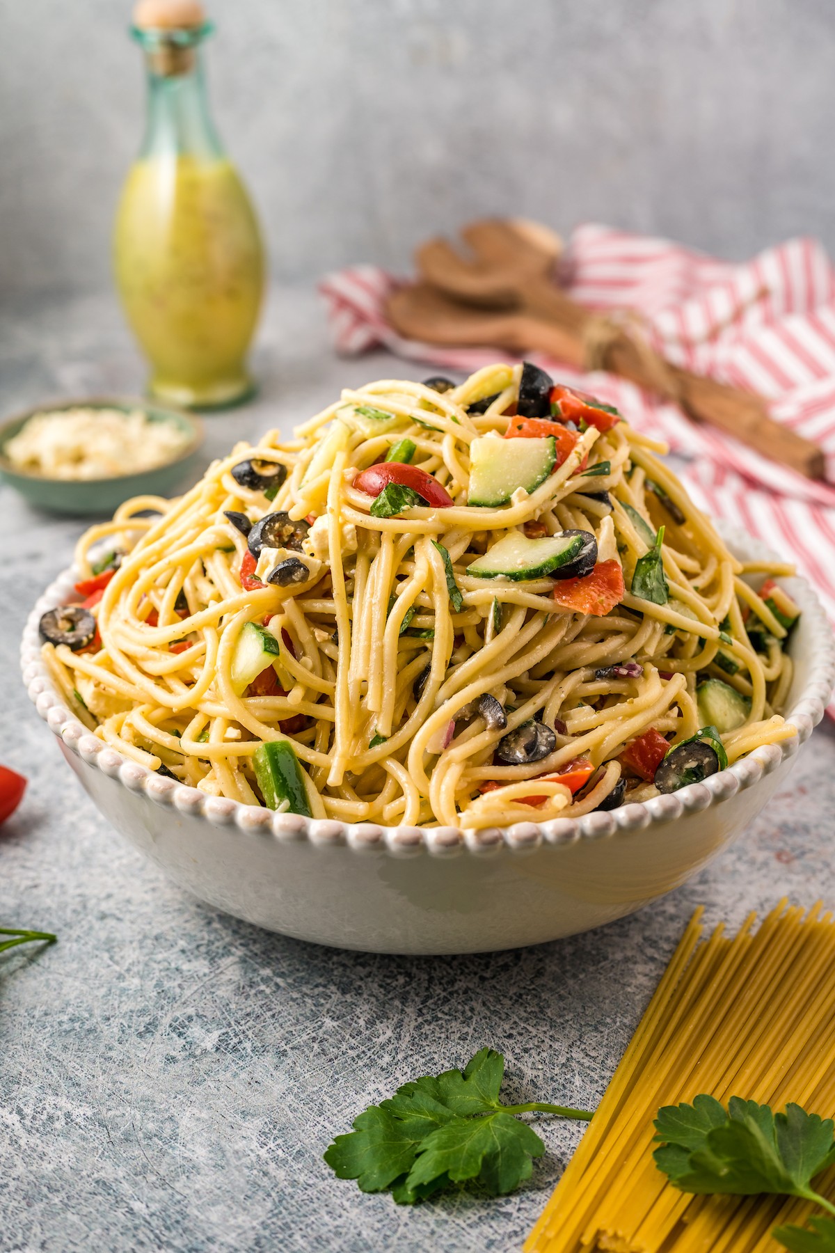 A large bowl of pasta salad with olives, tomatoes, and more.
