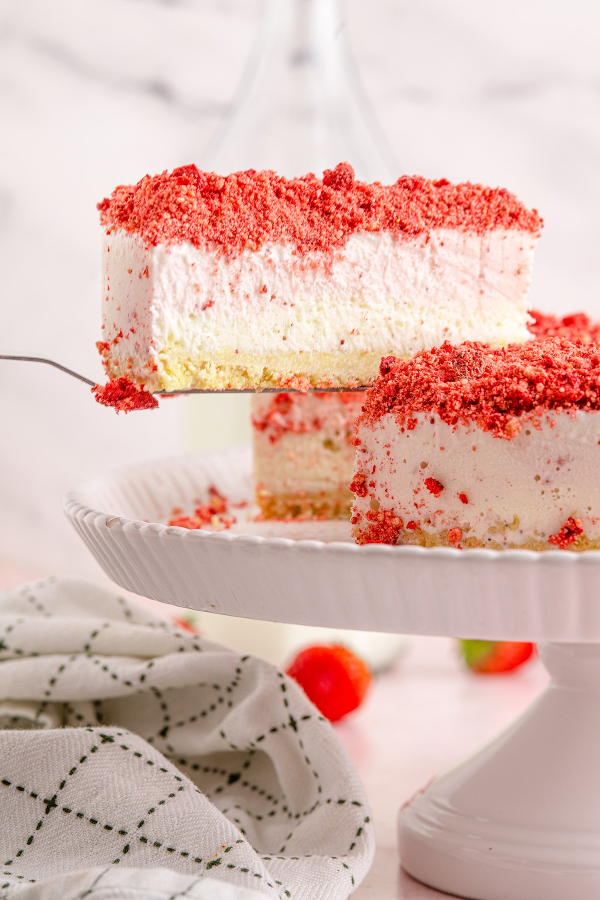 Lifting a slice of ice cream cake from a cake stand.