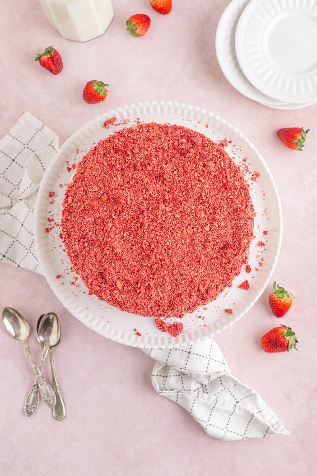 A crumb-topped strawberry shortcake ice cream cake on a cake stand.