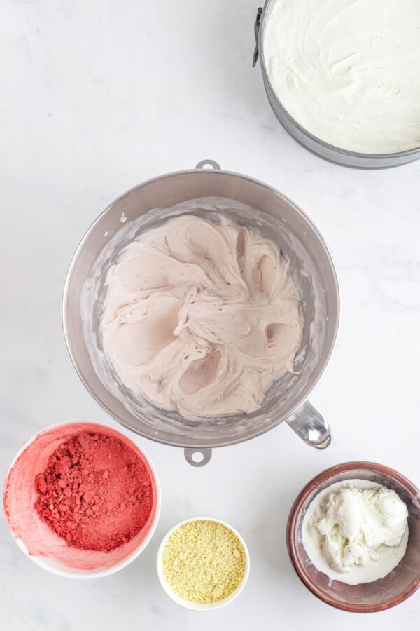 Whipped strawberry ice cream in a stand mixer.