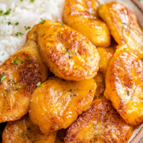 Sweet plantains on a plate with rice and beans.