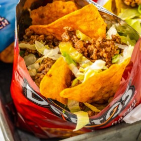 Overhead shot of a taco in a bag, made with doritos and toppings.