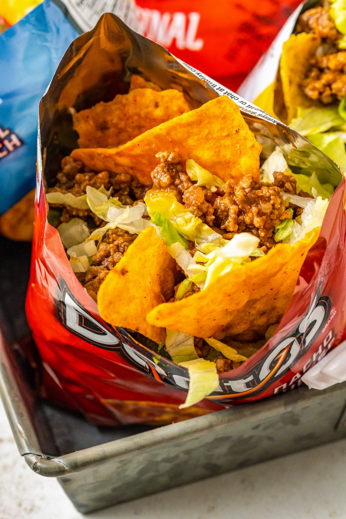 Overhead shot of a taco in a bag, made with doritos and toppings.