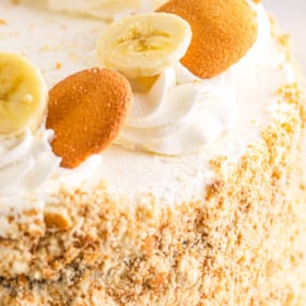 Banana pudding cake garnished with banana slices and nilla wafers.