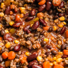 A pot of stovetop chili with beans, carrots and corn.