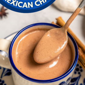 A mug of Champurrado with a spoon lifting the drink out of the cup showing how thick it is.