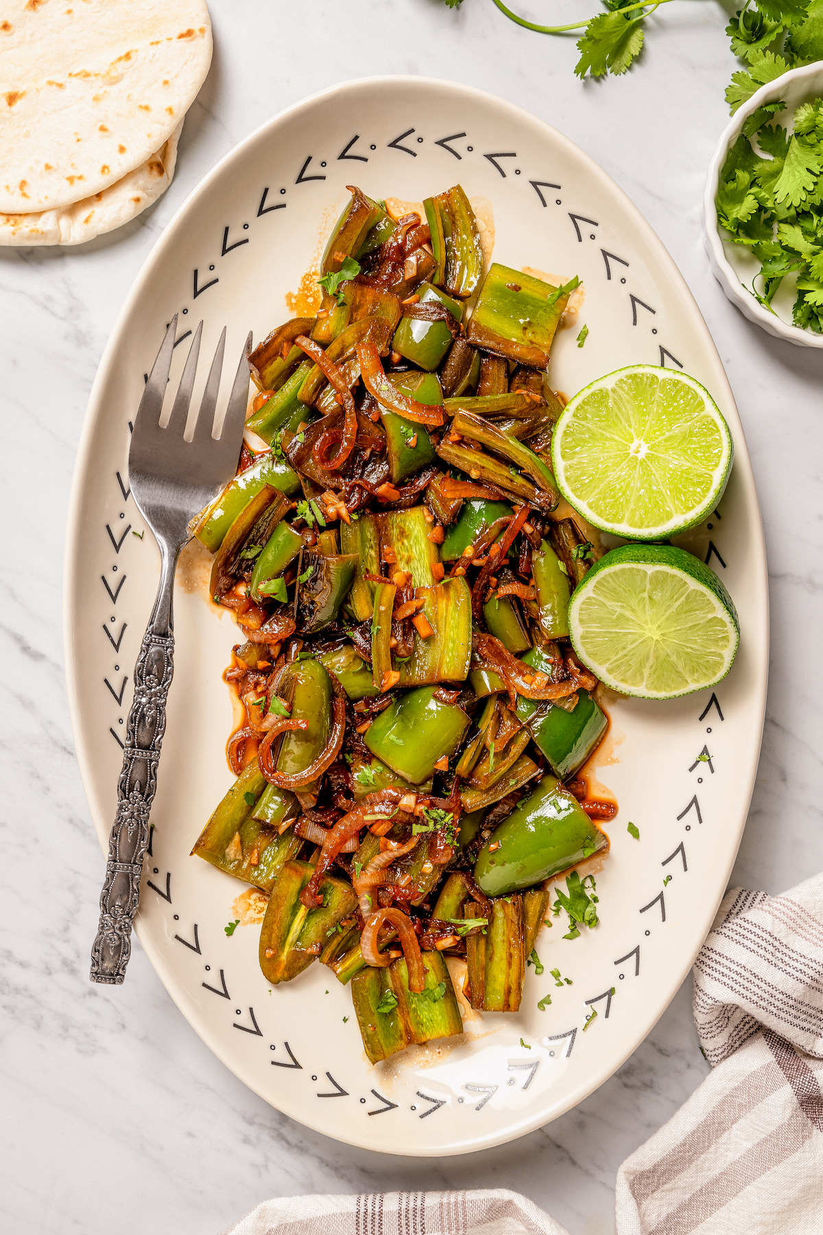 Chiles toreados with lime wedges on the side.