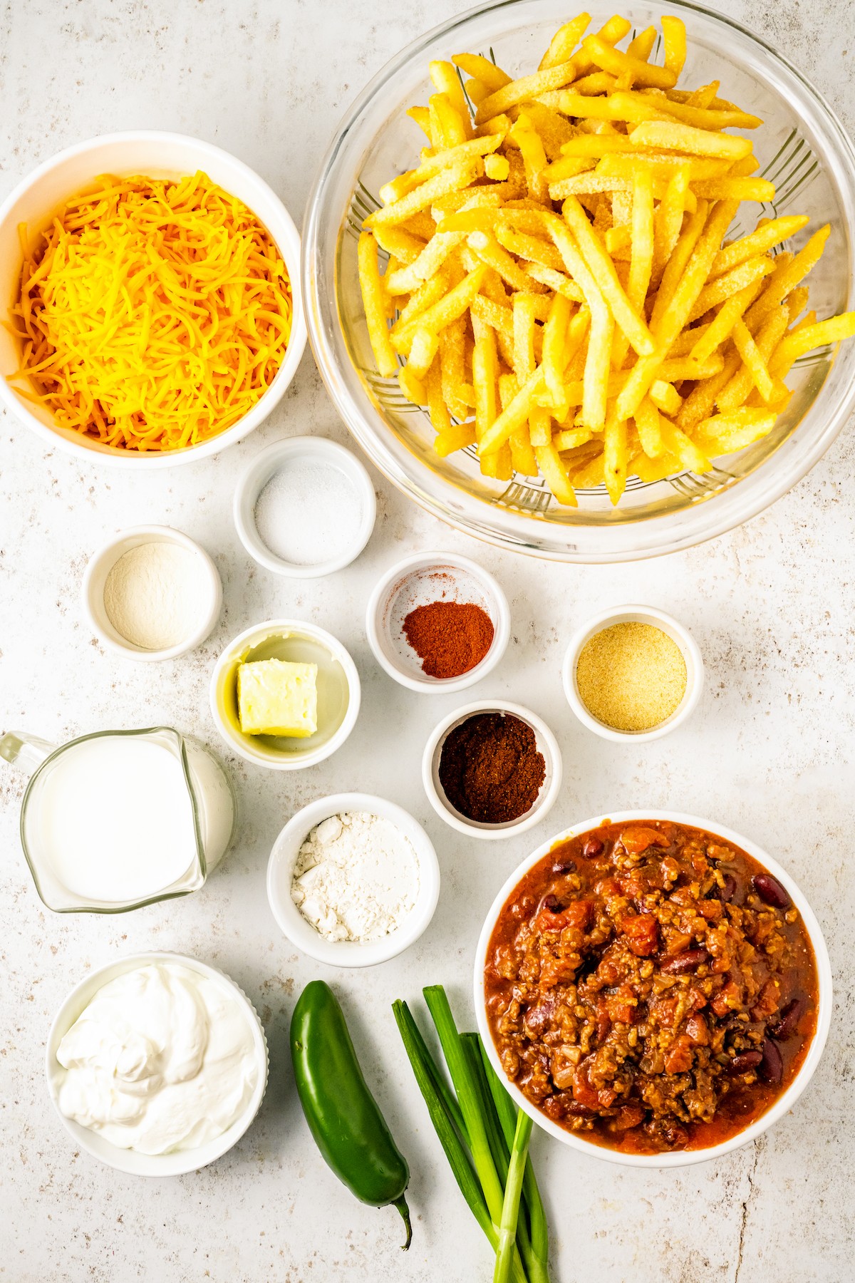 Ingredients for chili cheese fries, measured and arranged on a work surface.