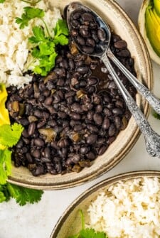 Bowl of Cuban black beans recipe with rice and avocado.