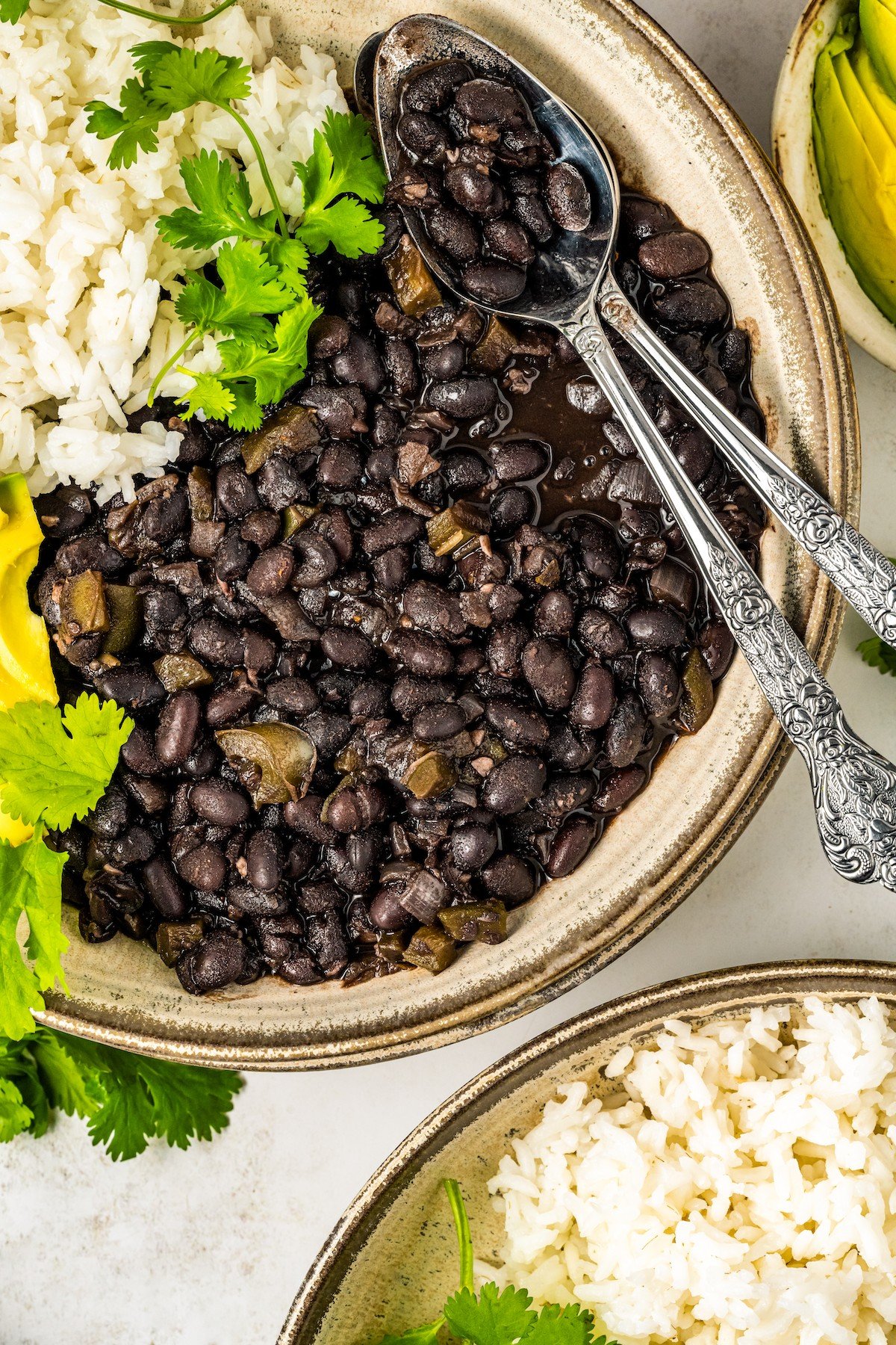 Bowl of Cuban black beans recipe with rice and avocado.