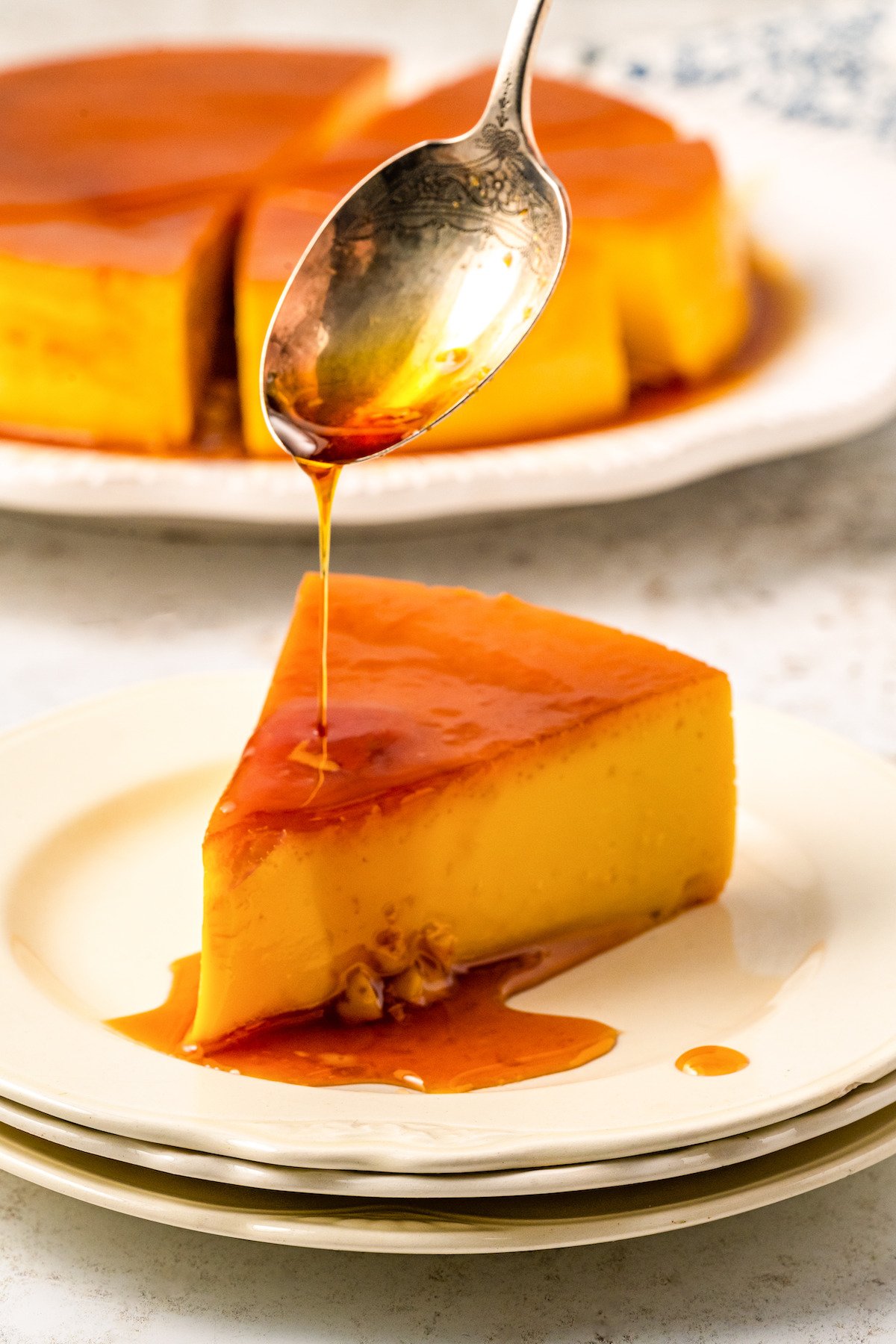 Drizzling caramel over a slice of flan.