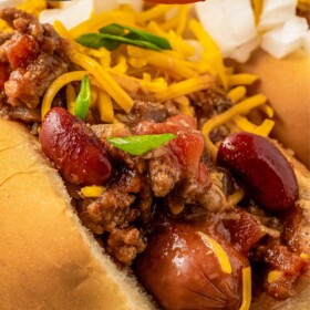 Hot dog chili on top of two hot dogs on a plate.