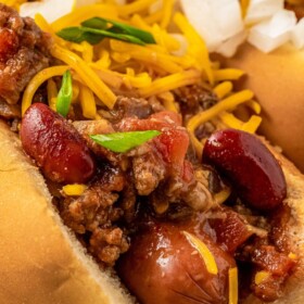 Hot dog chili on top of a hot dog on a plate.