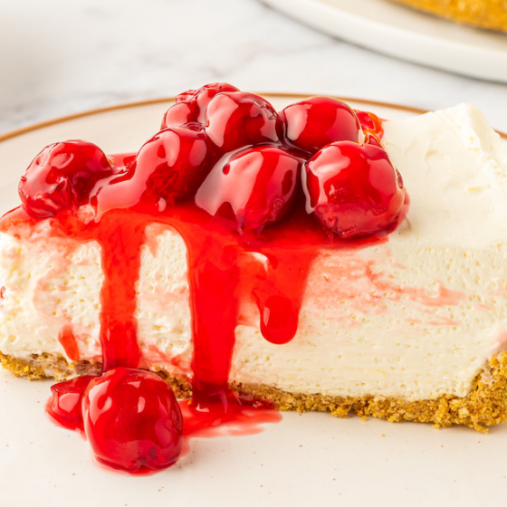 A single serving of no-bake cherry cheesecake on a white plate.