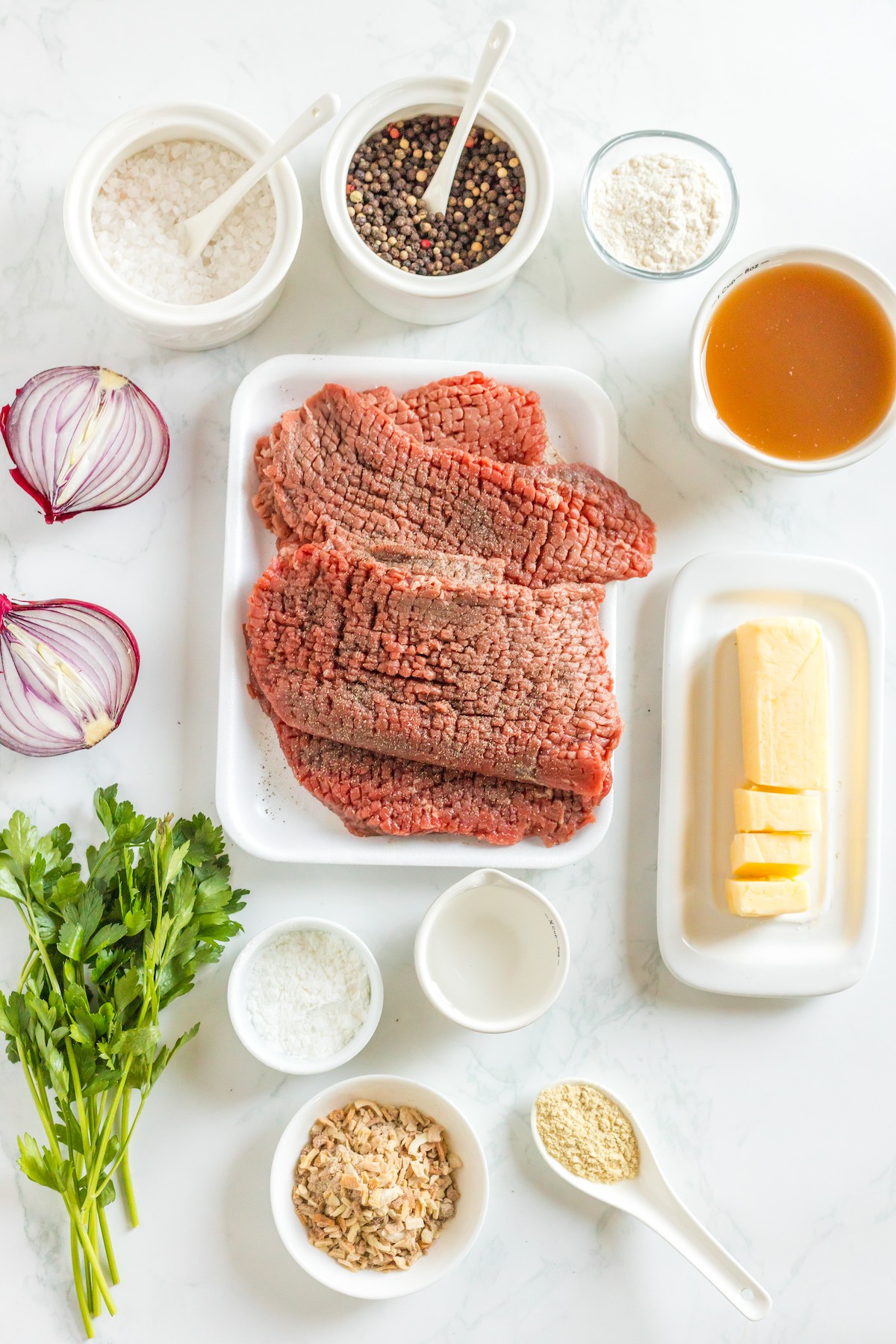 Ingredients for cube steak arranged on a work surface.