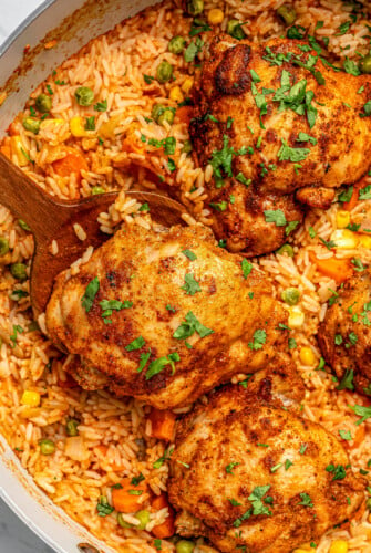 Close-up of arroz con pollo in a wooden spoon.