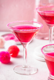 Dragon fruit pink martini in a martini glass with a pink sugar rim.