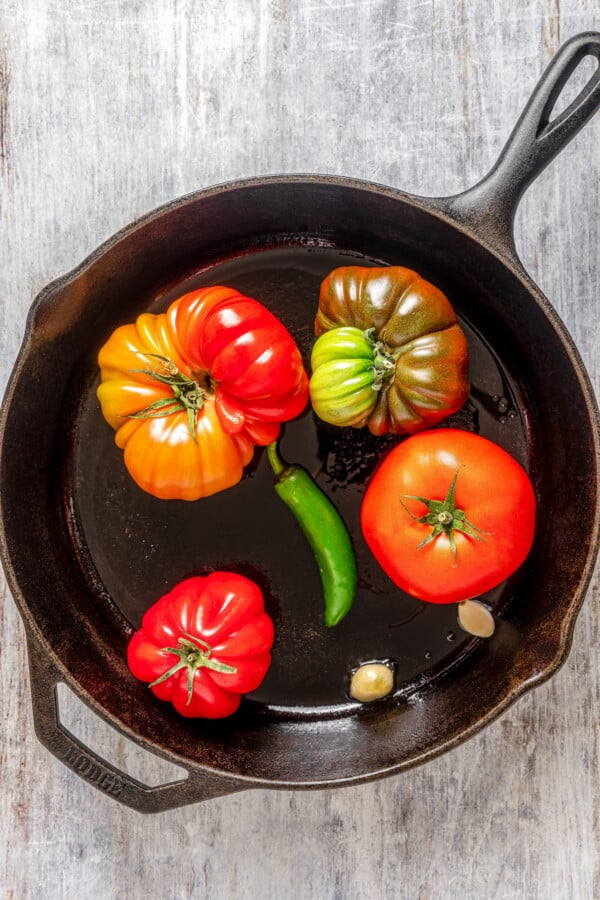 Tomatoes, jalapeno and garlic in a cast iron skillet.