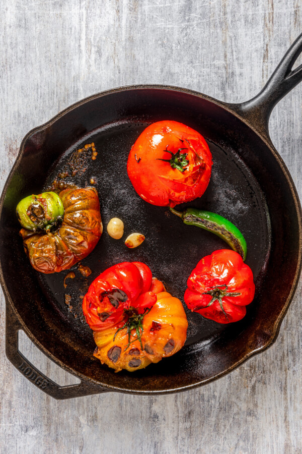Blistered tomatoes, jalapeno and garlic in a cast iron skillet.