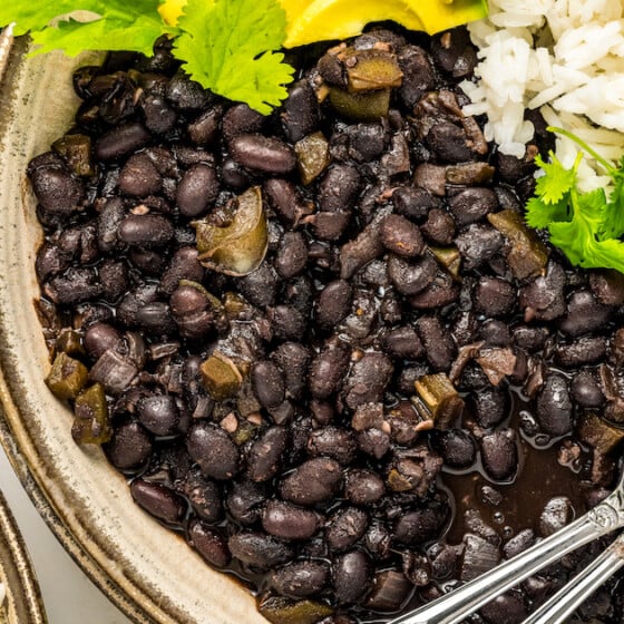 A plate of cuban black beans with rice and avocado.