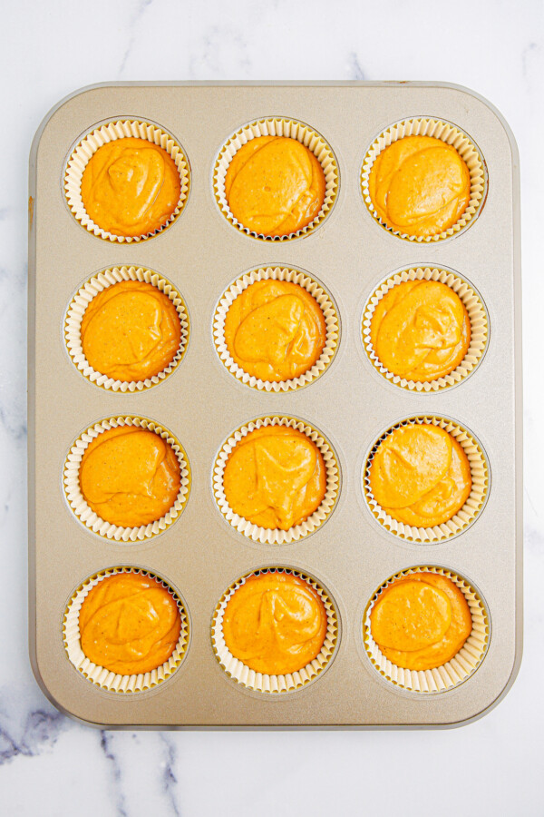 Unbaked cupcakes in a muffin tin.