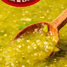 A bowl of homemade salsa verde with a wooden spoon scooping up a serving.