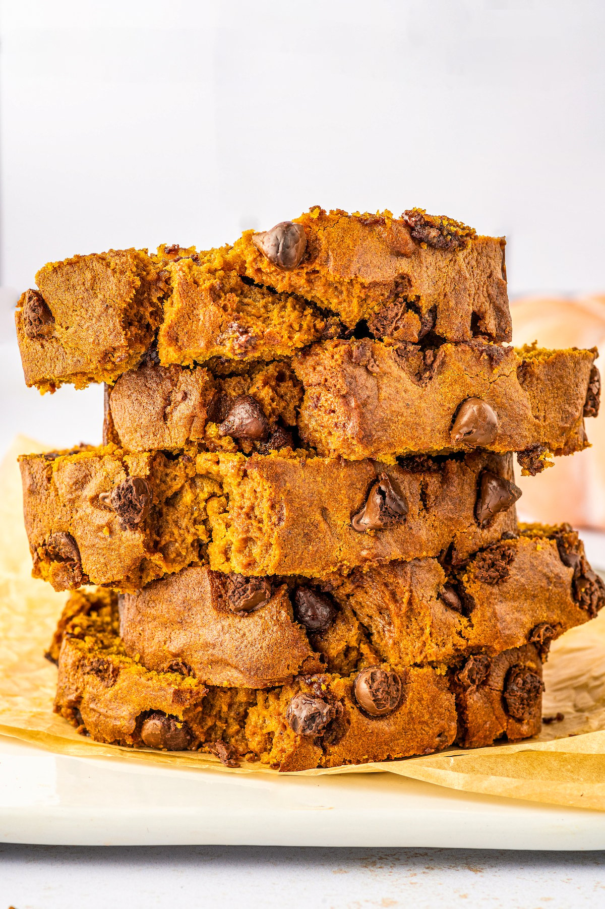 Slices of pumpkin chocolate chip bread stacked on top of each other.