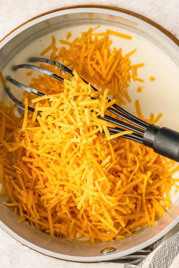 Whisking cheese into creamy sauce.