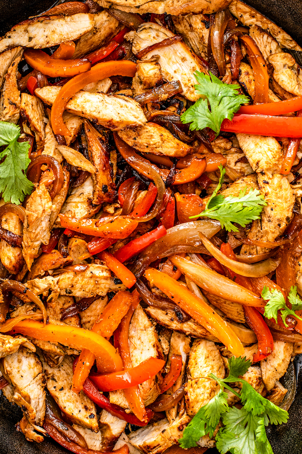 Overhead shot of a skillet of fajitas made with chicken and vegetables.