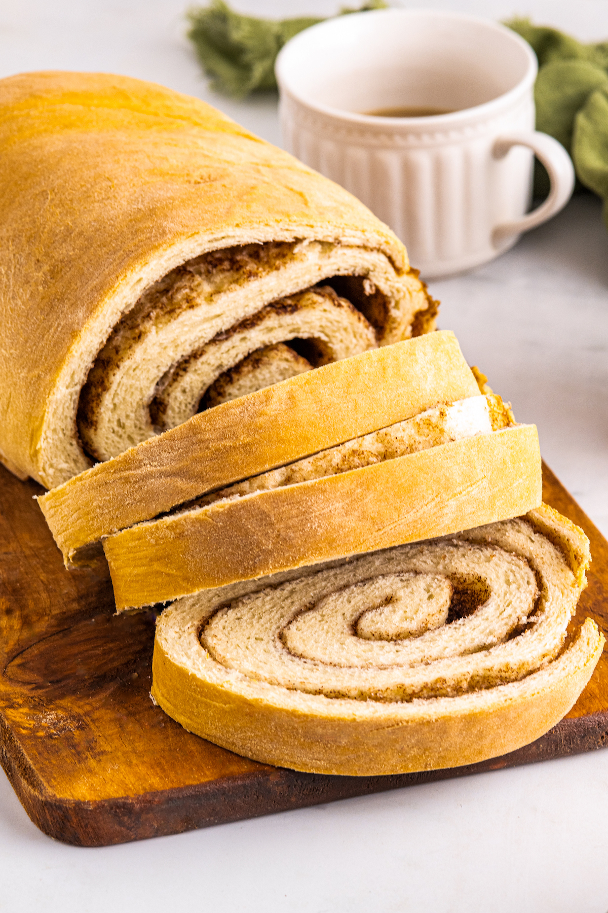 A loaf of cinnamon bread with several slices cut off to show the swirl.