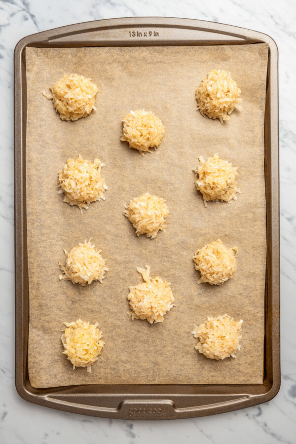 A parchment-lined tray of unbaked cocadas.