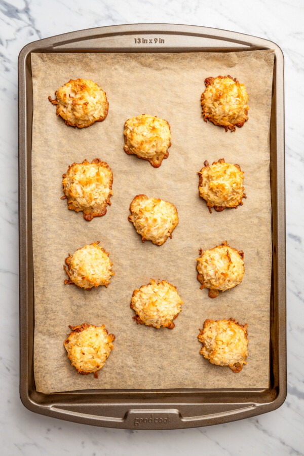 A parchment-lined tray of baked cocadas.