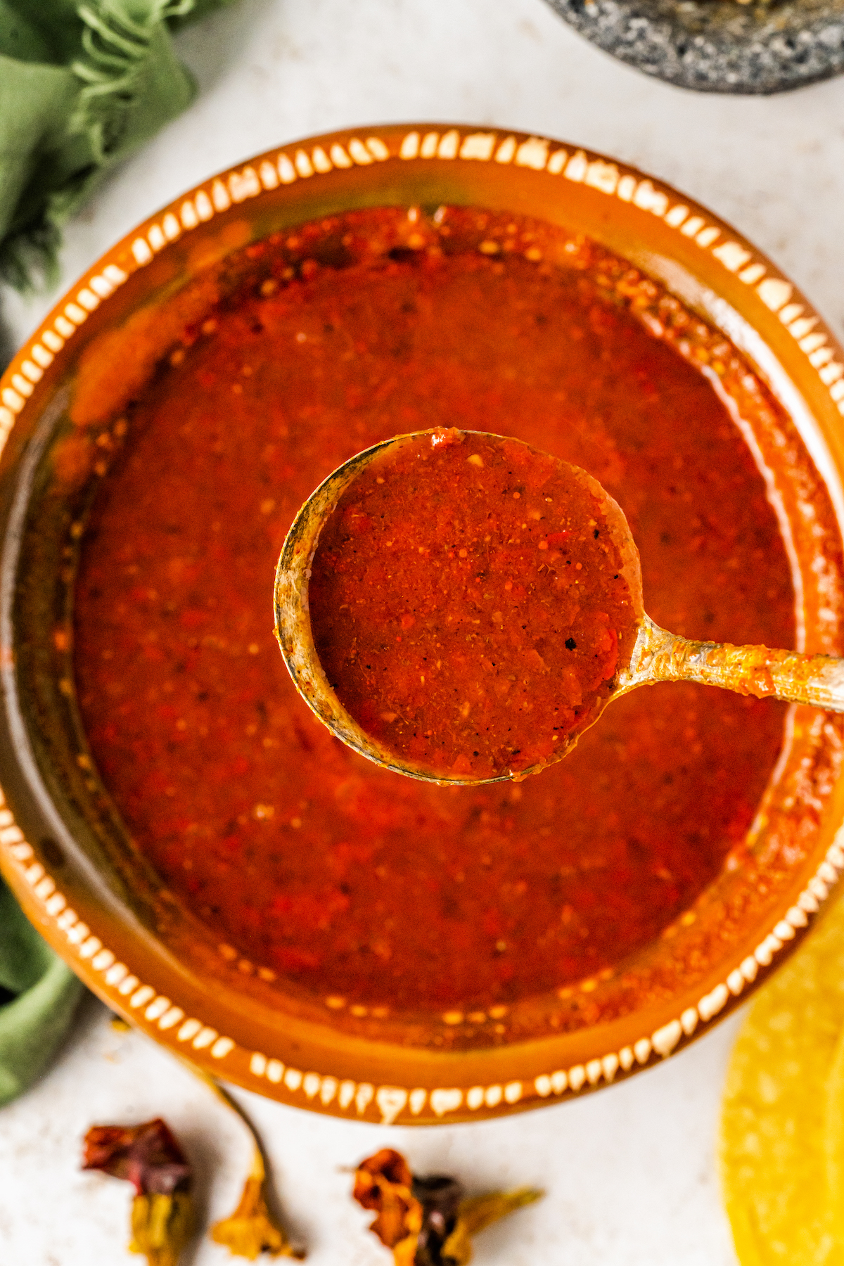 Guajillo Sauce in a bowl with a ladle scooping up a serving.