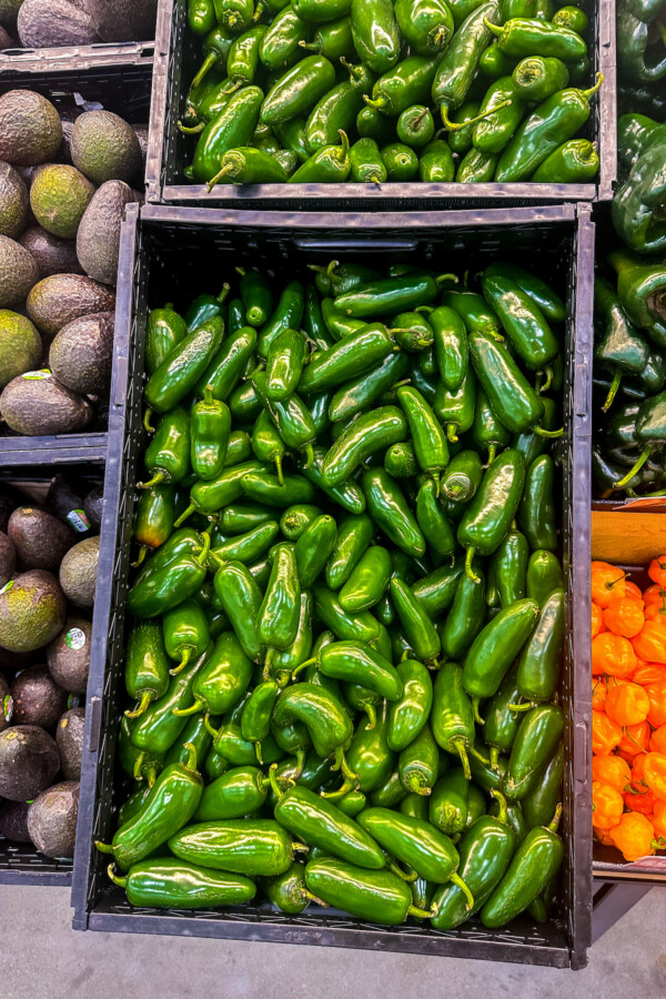 A bunch of Jalapeños in grocery store crates.