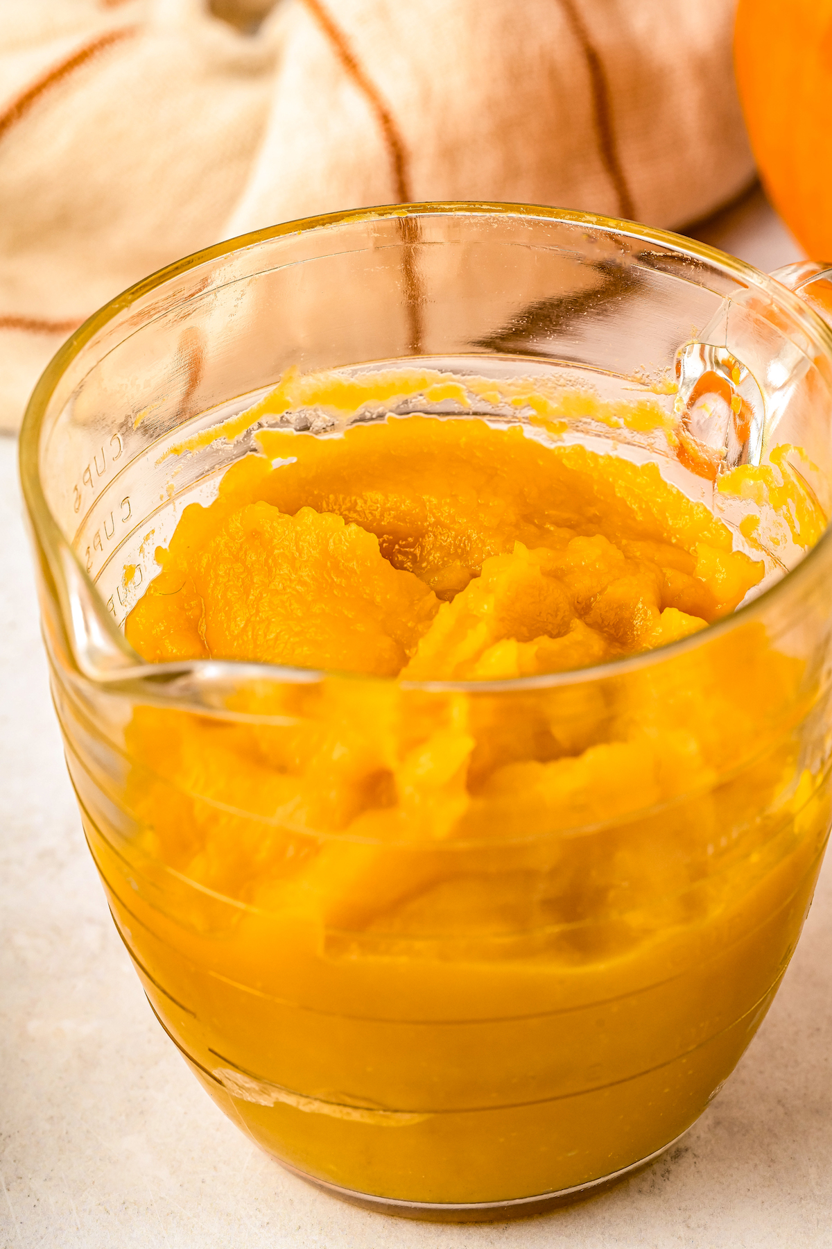 A glass measuring cup of pumpkin puree.