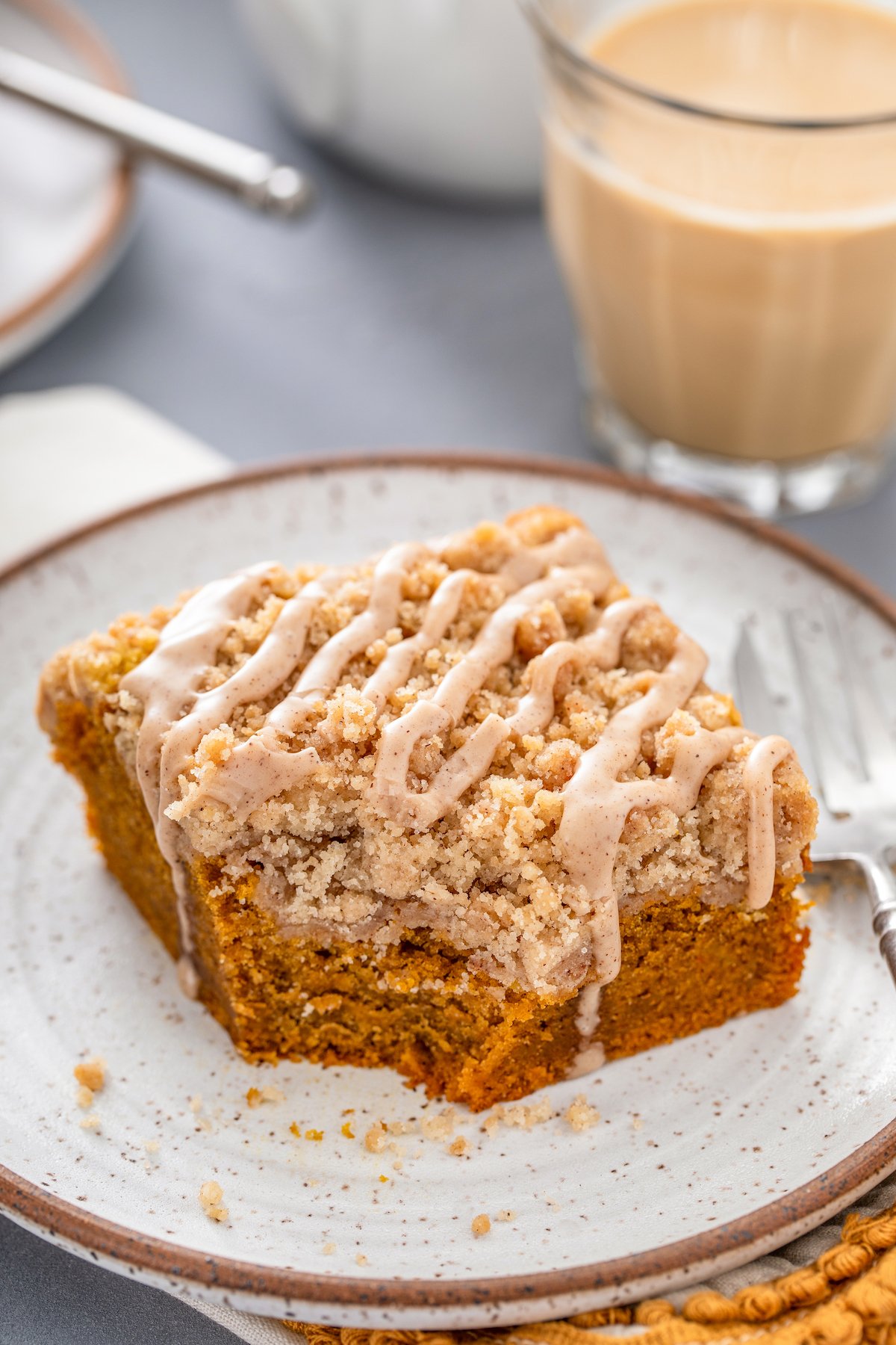 A square of pumpkin coffee cake, with a bite cut from it.