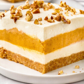 Layered pumpkin dessert topped with chopped nuts.