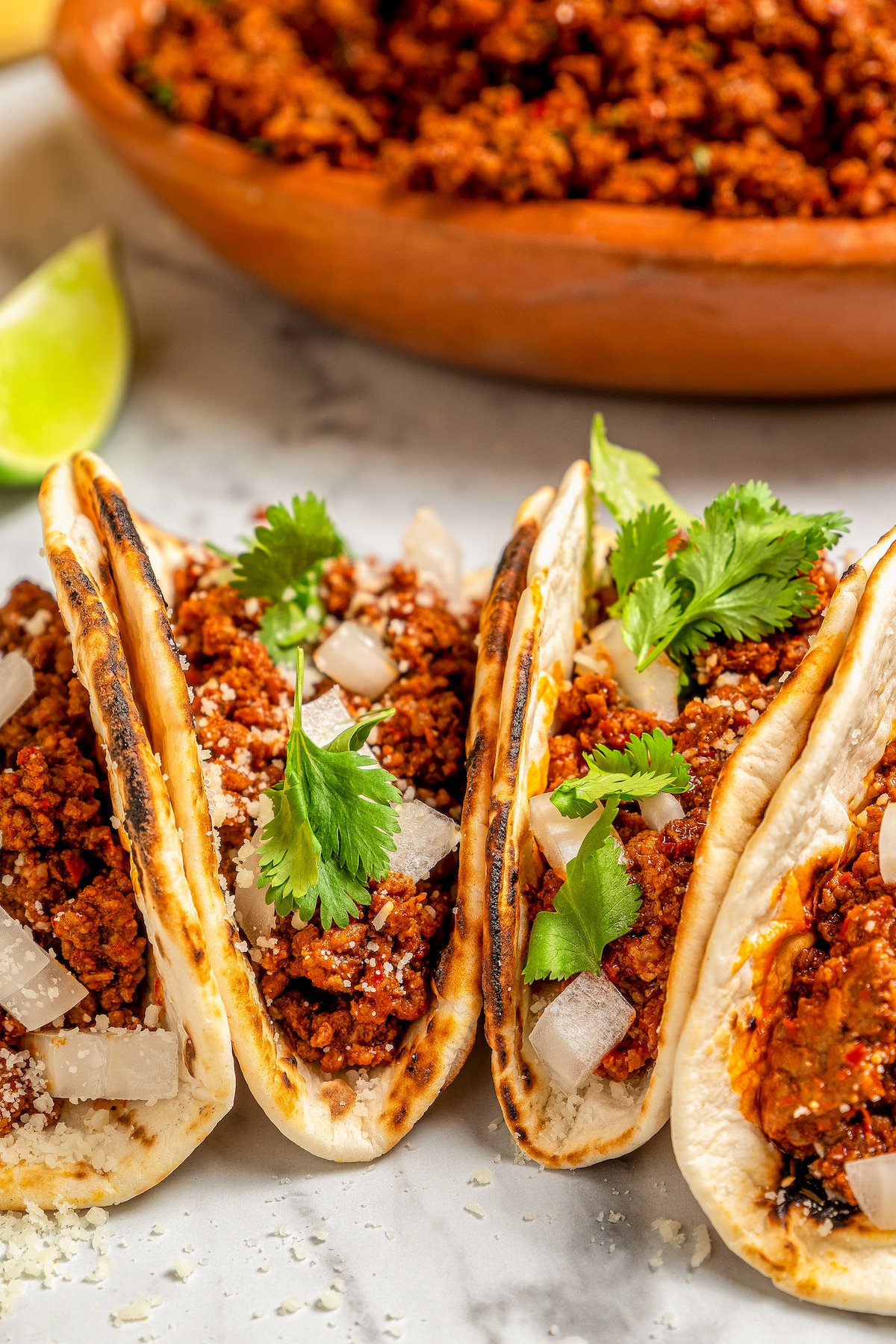Flour tortillas stuffed with spicy taco meat and topped with cilantro, onion and cheese.