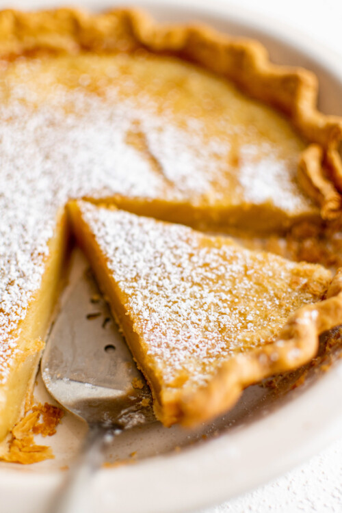 Lifting a slice of pie from a dish.