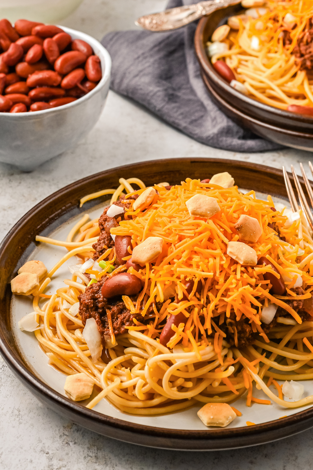 A plate of cincinnati chili loaded with toppings.