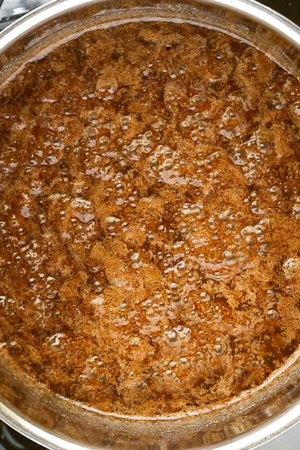Brown sugar and apple cider sauce bubbling in a sauce pan.