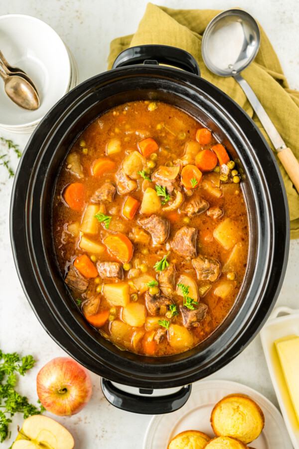 Cooked beef stew with apple cider in a crockpot.