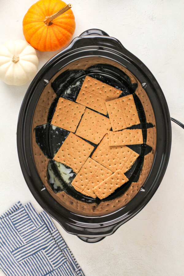 Graham crackers in the bottom of a crock pot insert.