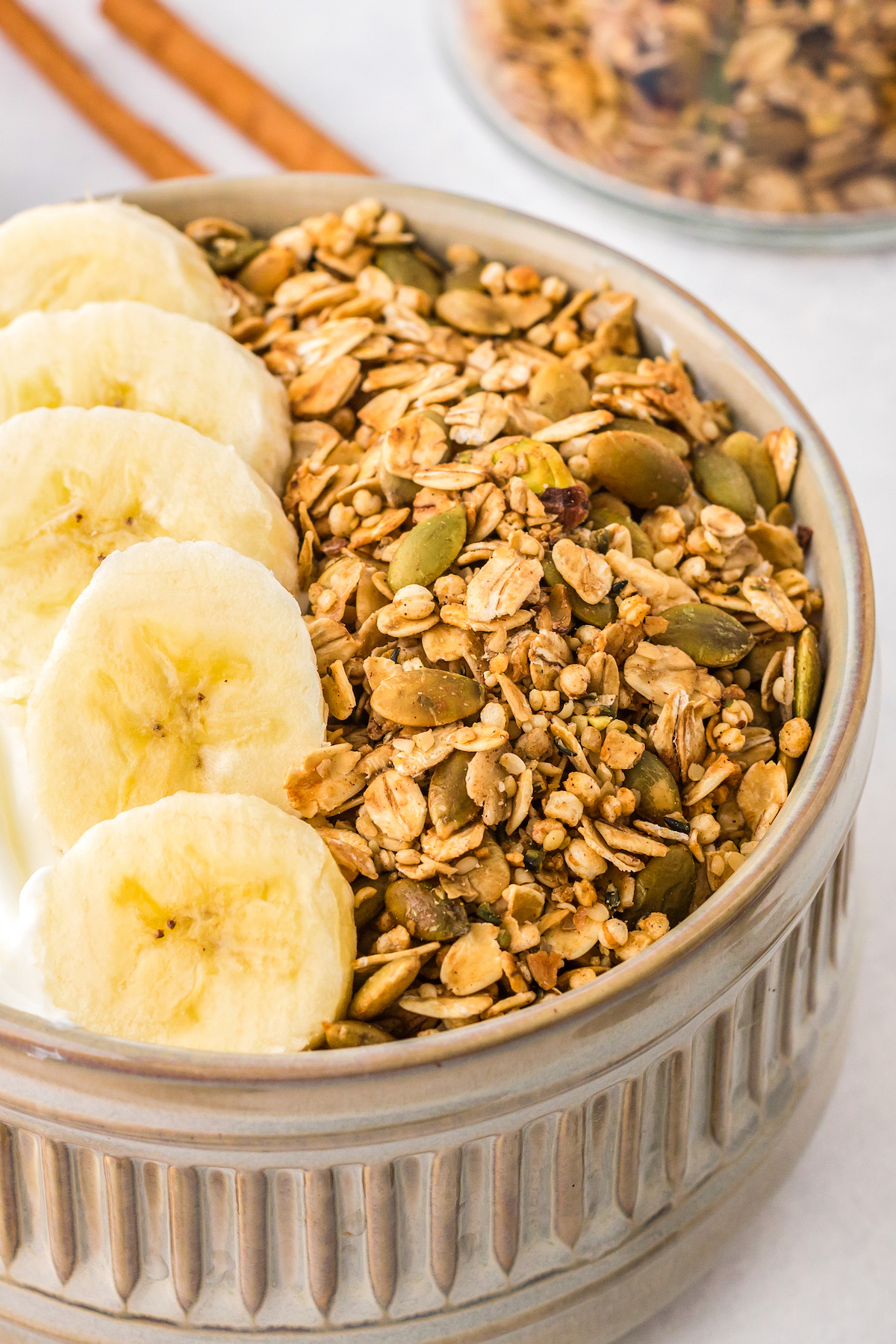 Homemade pumpkin spice granola served with banana slices in a bowl.