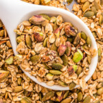 A close-up shot of granola in a wooden spoon.