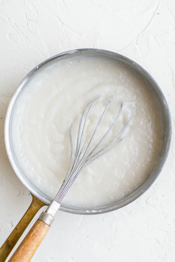 Whisking a creamy mixture in a saucepan.