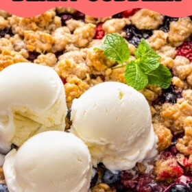 Mixed berry cobbler in a skillet with three scoops of vanilla ice cream on top and a spoon scooping out a serving.