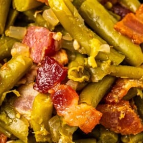 Green beans with bacon on top in a bowl.