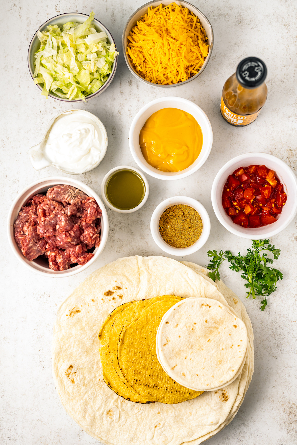 Ingredients for a Taco Bell crunchwrap supreme recipe arranged in bowls. 